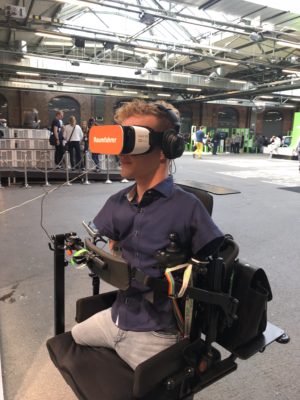 Janis McDavid in seinem E-Rollstuhl trägt eine VR-Brille