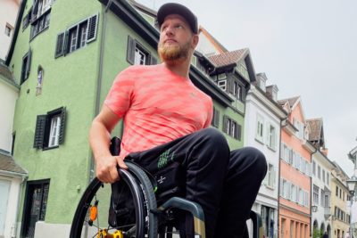 Ein junger, sportlicher Mann, der in einem Aktivrollstuhl der Küschall K-Serie sitzt